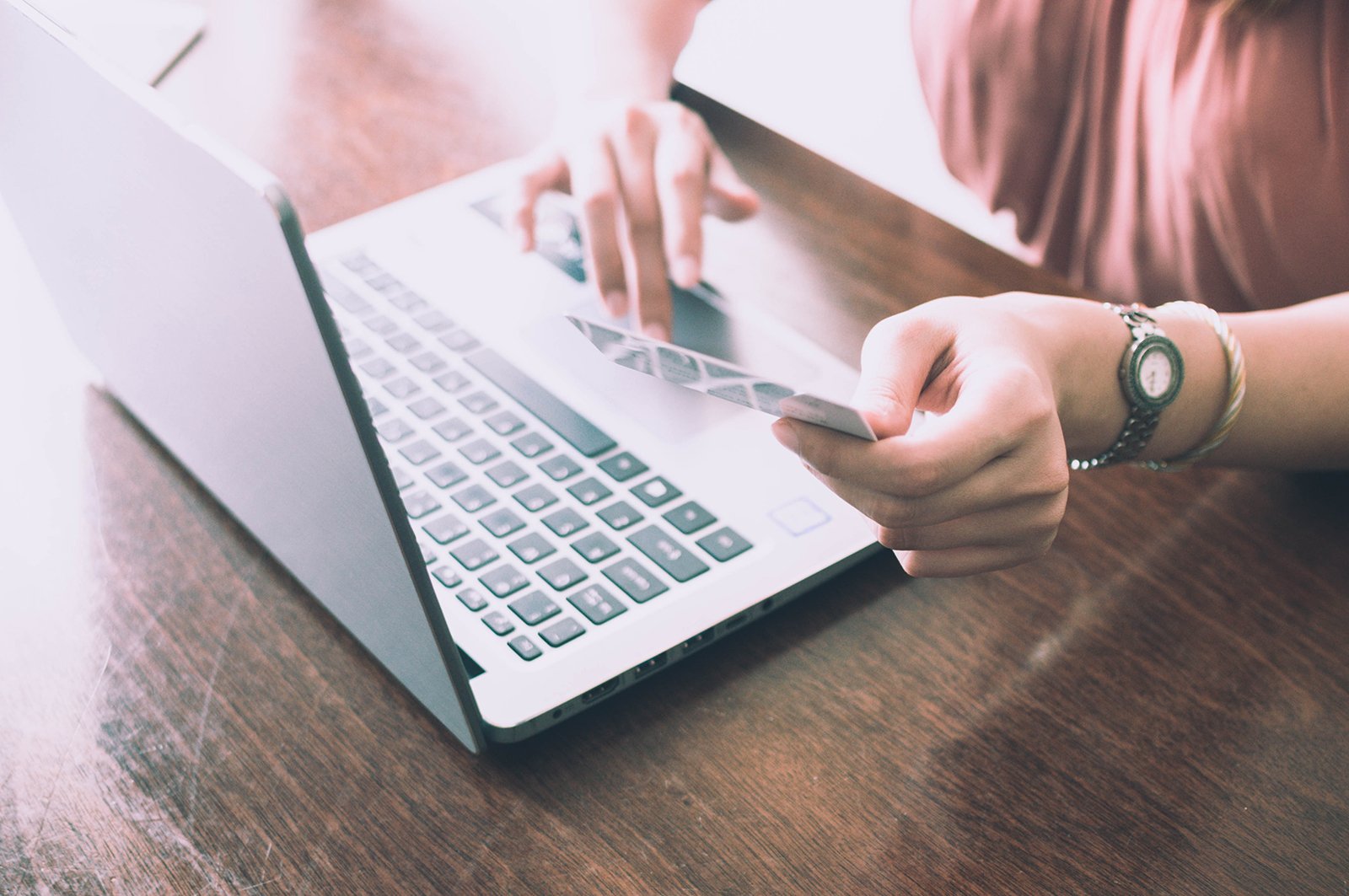 computer and a credit card in hand
