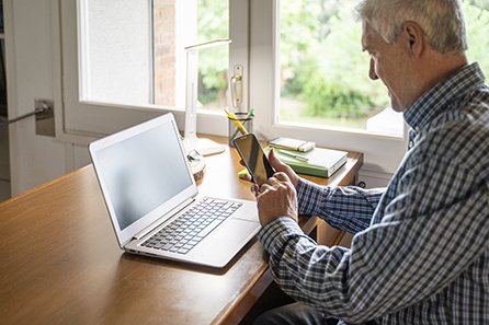 man looking at phone and computer